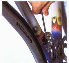 Screw in the high adjuster (usually marked “H”) to bring the outer side of the front derailleur cage to about 2mm from the chain. 